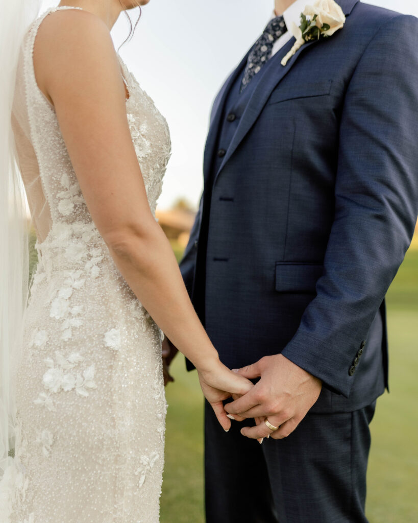 Arizona cis-het wedding at Mountain Shadows Resort holding hands with gorgeous beaded wedding gown details