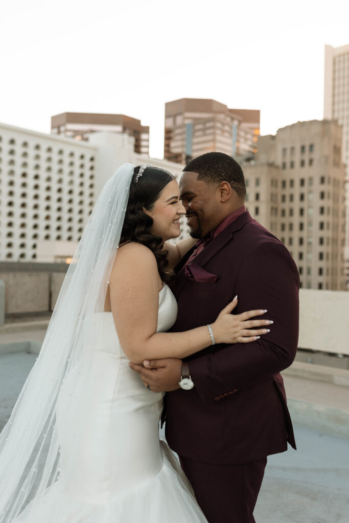 Latina bride & Black groom laughing and hugging at downtown Phoenix wedding venue