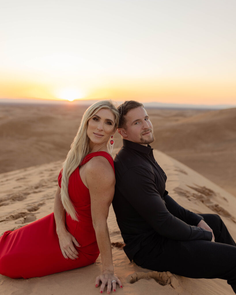 Engaged couple in formal clothing posed in the sane dunes