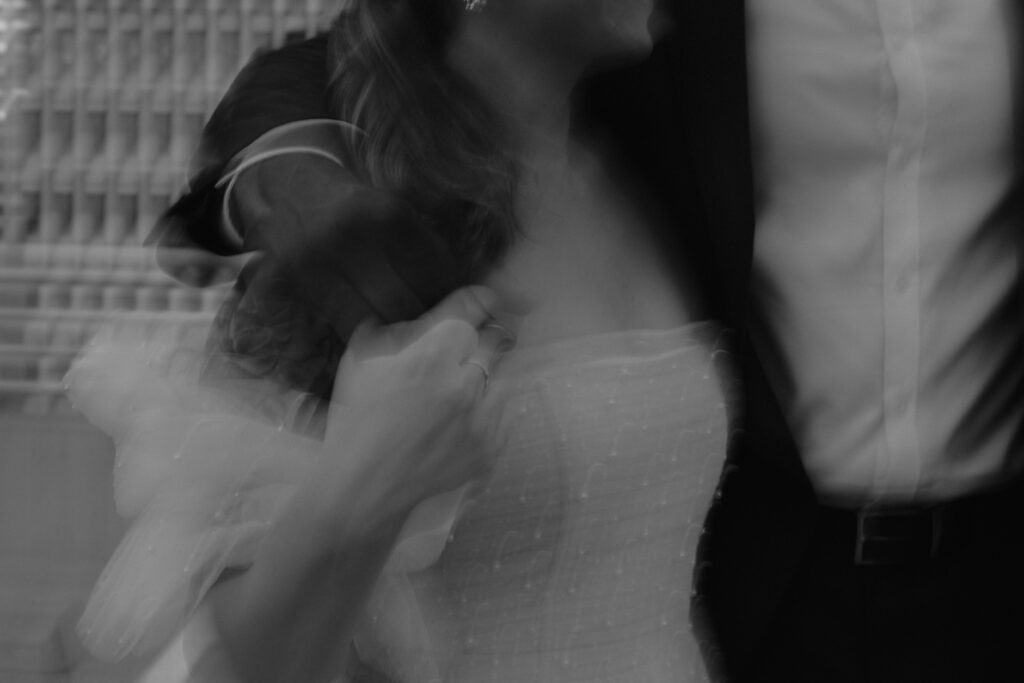Blurred handholding bride and groom at downtown wedding venue