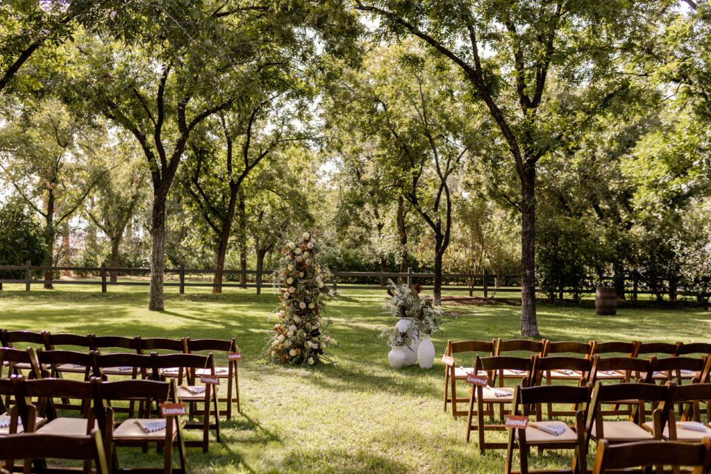 Arizona wedding venue, The Grove, ceremony set up with gorgeous altar flowers and wooden chairs