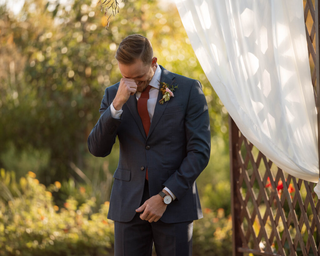Groom crying while bride walks down the aisle at Arizona wedding venue