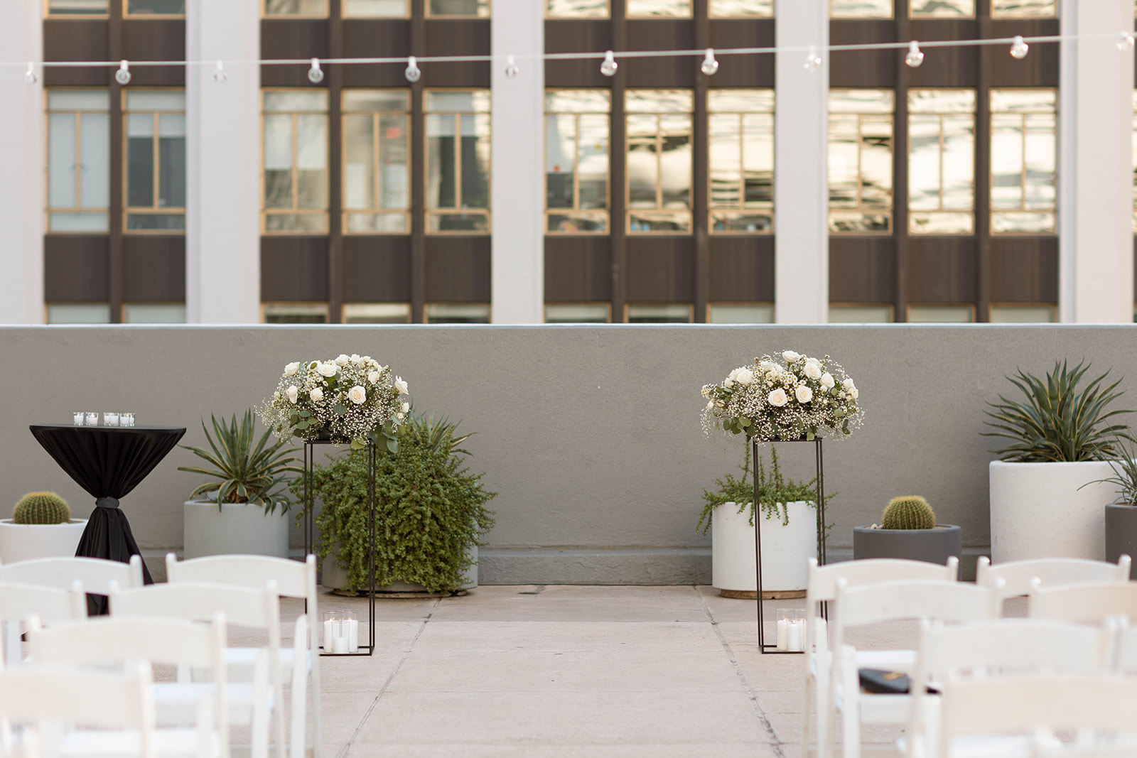 Ceremony set up of downtown wedding venue in phoenix, arizona. Features two floral arrangements with white flowers and baby's breath on stands.