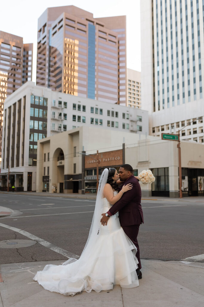 Latina bride and black groom kissing in downtown Phoenix Arizona